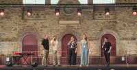 Quatre chanteurs sur scène devant les élèves spectateurs